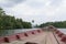 View over the prow of a well used wooden boat travelling up River Kong and cutting through the dense jungle