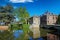 View over water town moat on  medieval romantic old cityscape, ancient stone bridge, clear blue sky