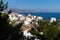 View over the white washed houses between fir trees with acient roofs to the ocean and the rock of Calpe, Altea, Costa Blanca,