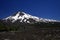 View over wide field of volcanic lava ash on peak of black Volcano Llaima with spots and stripes of snow and ice