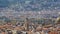 View overlooking maroon rooftops and towers of big city on sunny day, panorama