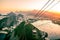 View overlooking Rio de Janeiro from the top of Sugarloaf mountain with cable car and the sun setting behind mountains