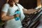 View of overweight girl with towel on shoulder holding sports bottle while standing at treadmill