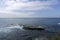 A view of Pacific Ocean and a rocky little island with colony of sea birds on it