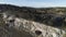 View of panorama from land of hilly valley. Shot. Top view of stone hills and horizon with blue sky. White observatories