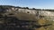 View of panorama from land of hilly valley. Shot. Top view of stone hills and horizon with blue sky. White observatories