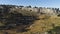 View of panorama from land of hilly valley. Shot. Top view of stone hills and horizon with blue sky. White observatories