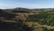 View of panorama from land of hilly valley. Shot. Top view of stone hills and horizon with blue sky. White observatories