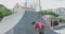 View of parkour athlete doing extreme flips on urban skateboard track and sits