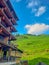 A view of part of a traditional old house in China. Chinese lanterns on balconies, tiled roofs. Background rice terrace fields and