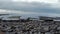 View of pebbles in the bay under a cloudy sky