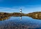 View of the Penmon Lighthouse in North Wales with reflections in a tidal pool
