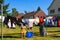 View of people hanging laundry on clothesline in backyard with houses and clear blue sky background