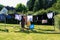 View of people hanging laundry on clothesline in backyard with houses and trees in background