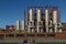 View people sit outdoor and background of high metal refinery tank, red painted structure and steel pipelines