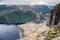View of people walking on Preikestolen Pulpit Rock from above with a fjord underneath