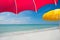 View of perfect pristine beach from under bright red umbrella