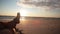 A view of a person crossing legs while lying on a sandy beach enjoying beautiful pastel sunset.