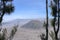 View of photogenic Batok volcano and Bromo crater through tropical vegetation. Picturesque valley of volcanic caldera with volcano