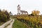 View of a picturesque white country church surrounded by golden vineyard pinot noir grapevine landscape with a gravel country road