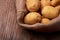 View of pile of new potatoes with jute bag on wooden desk