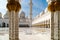 View through pillars to flowers and arabesques on floor and domes of Grand Mosque Abu Dhabi, UAE