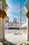 View through pillars to flowers and arabesques on floor and domes of Grand Mosque Abu Dhabi, UAE