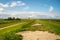 view on Pilsum lighthouse in the landscape of East Frisia with tourists walking around the dike and taking photographs