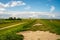 view on Pilsum lighthouse in the landscape of East Frisia with tourists walking around the dike and taking photographs