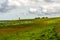 view on Pilsum lighthouse in the landscape of East Frisia with tourists walking around the dike and taking photographs