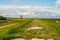 view on Pilsum lighthouse in the landscape of East Frisia with tourists walking around the dike and taking photographs