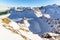 View from Pitztal glacier into the high alpine mountain landscape with cable car station and ski slope in winter with lots of snow