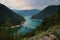 A view into the Piva lake going through a valley with an old rusty bridge connecting both shores