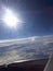 View from the plane on the clouds, the distant land and the wing.