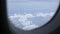 view through the plane window with thick cloud above the beautiful ocean of clouds over sea ocean coast landscape in tropical