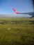 View from the plane window to the African green fields with trees