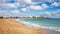 View of Playa de los Pocillos beach in Puerto del Carmen town, Lanzarote. Panorama of sandy beach with turquoise ocean