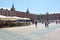 View of Plaza Mayor, the Main Square of Madrid. People walking and sculpture of the king Felipe III on a bright sunny spring day