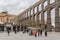 View at the Plaza Oriental and Towering Roman aqueduct and grand landmark monument of Segovia, tourists visiting on Segovia