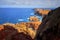 View of the Ponta de SÃ£o LourenÃ§o lighthouse. Dramatic cliffs, blue ocean, cloudy sky.