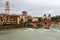 View of the Ponte Pietra brick arch bridge over the Adige river and the bell tower of the Cathedral in Verona