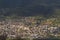 A view of a populated area village in a green valley in the morning at sunrise, against a dramatic back of mountains and