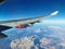 View from the porthole on the wing of an airplane with a red aircraft engine flying to Cyprus, in the morning over the beautiful