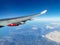 View from the porthole on the wing of an airplane with a red aircraft engine flying to Cyprus in the morning over beautiful