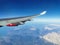 View from the porthole on the wing of an airplane with a red aircraft engine flying to Cyprus in the morning over beautiful