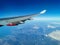 View from the porthole on the wing of an airplane with a red aircraft engine flying to Cyprus in the morning over beautiful