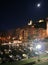 View of the Portovenere buildings at night under the moon with the illuminated cathedral and the harbor with moored boats