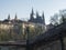 View of Prague Castle and St. Vitus Cathedral gothic churche, Hradcany through barbed wire fence from Queen Annes Summer