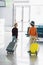 View of preteen kids with suitcases in waiting hall in airport