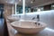 view Public bathroom setting row of white ceramic washbasins and faucets